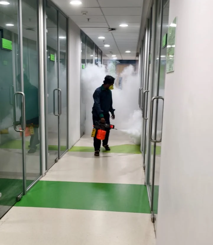 Pest Management India technician carrying out a fogging treatment in an office corridor