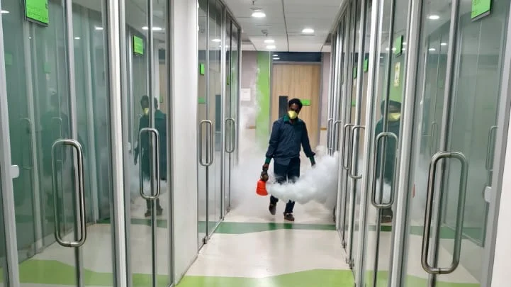 Pest Management India technician in full PPE thermal fogging a commercial corridor in Mumbai